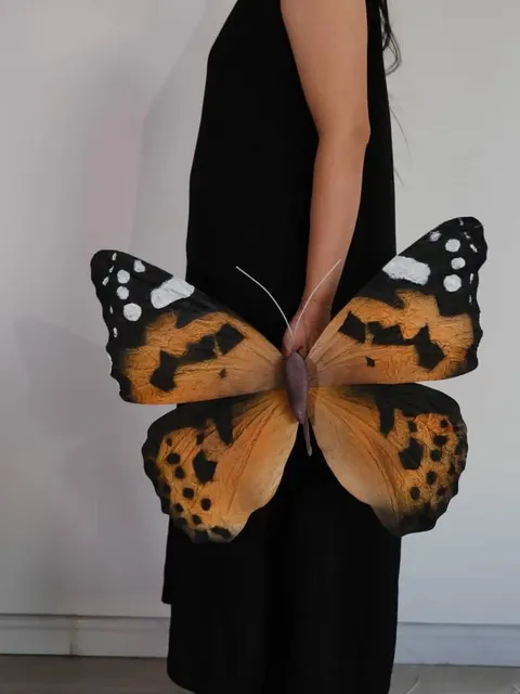 Giant monarch butterfly held by a maker